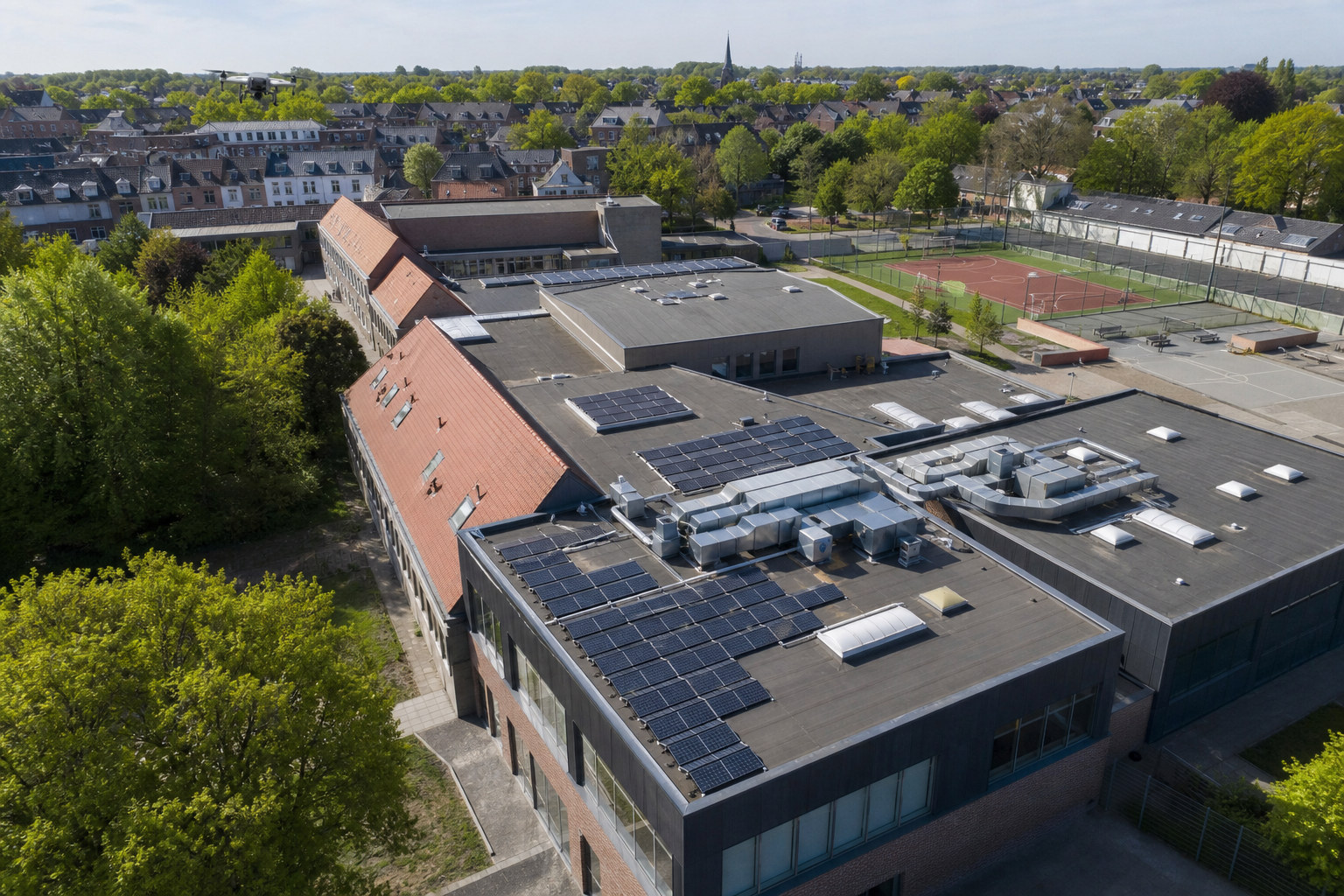 Publiek schoolgebouw met verschillende dakvormen en zonnepanelen